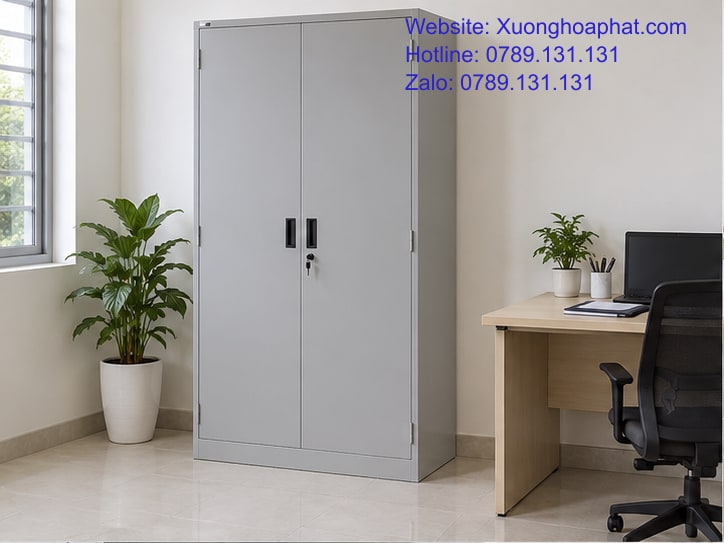 Tủ Sắt Văn Phòng Cho Hồ Sơ Chung Và Tài Liệu Riêng 2 Tủ sắt văn phòng cánh kín màu ghi cạnh bàn làm việc.